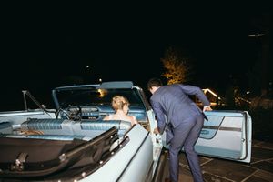 Nighttime scene shows people signing documents on car hood. Luxury Estate Wedding Photographer in NC