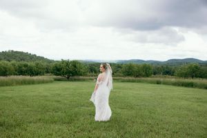 Dramatic cloudy sky frames wedding photography session in mountain meadow. Luxury Estate Wedding Photographer in NC