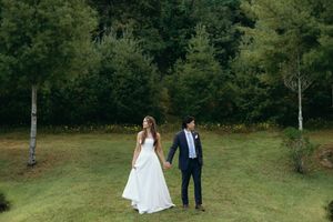 Wedding couple photographed from a distance in a scenic mountain meadow. Luxury Estate Wedding Photographer