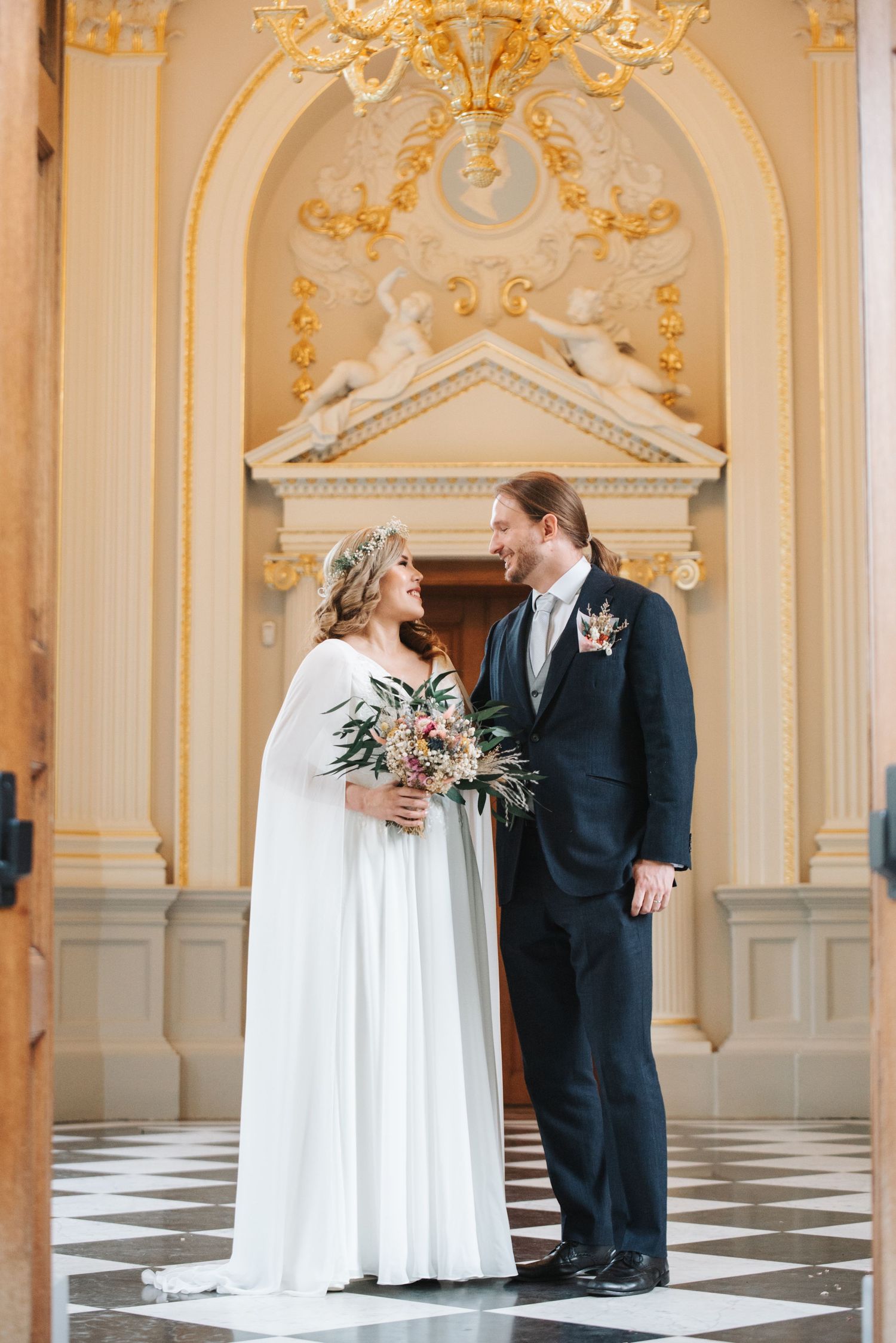 Elegant wedding photos in an ornate palace ballroom with gold trim and chandeliers.