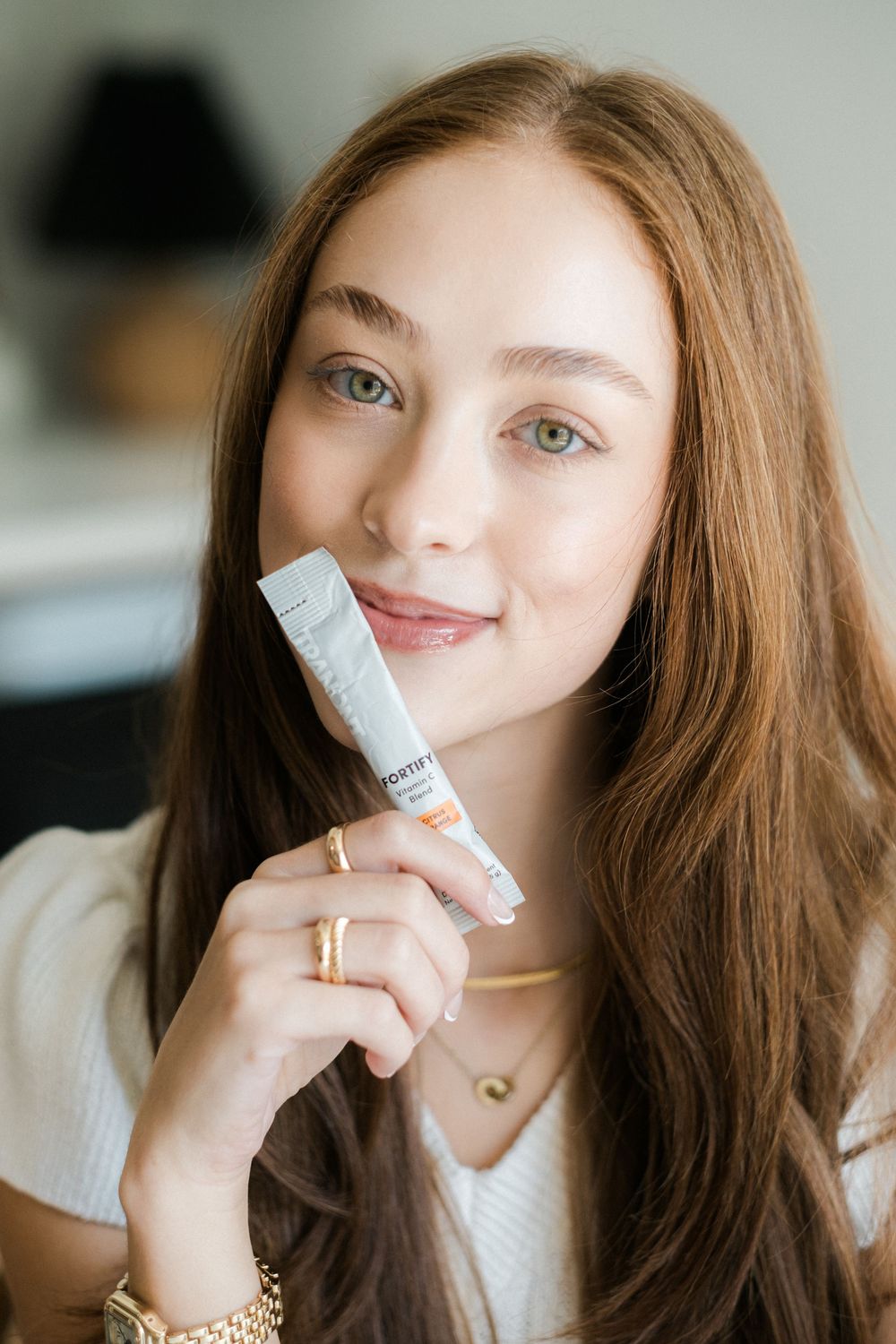 A series of beauty product application shots showing someone holding and applying lip balm in different poses.