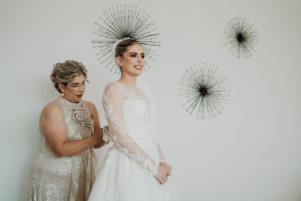 Two people share an emotional moment beside decorative starburst wall art at an elegant wedding celebration.