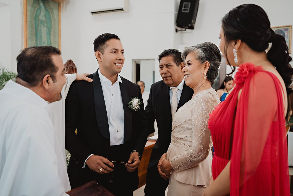 Wedding guests in formal attire mingle and socialize during a reception celebration.