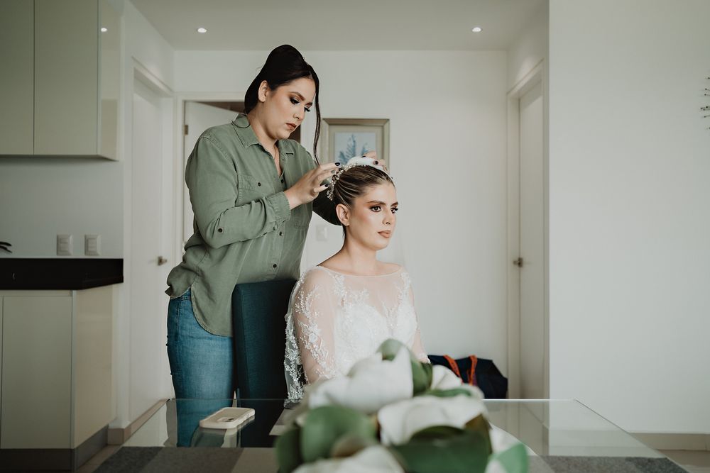 A styling session with final touches being made to a bride's hair during wedding preparations in a bright kitchen setting.