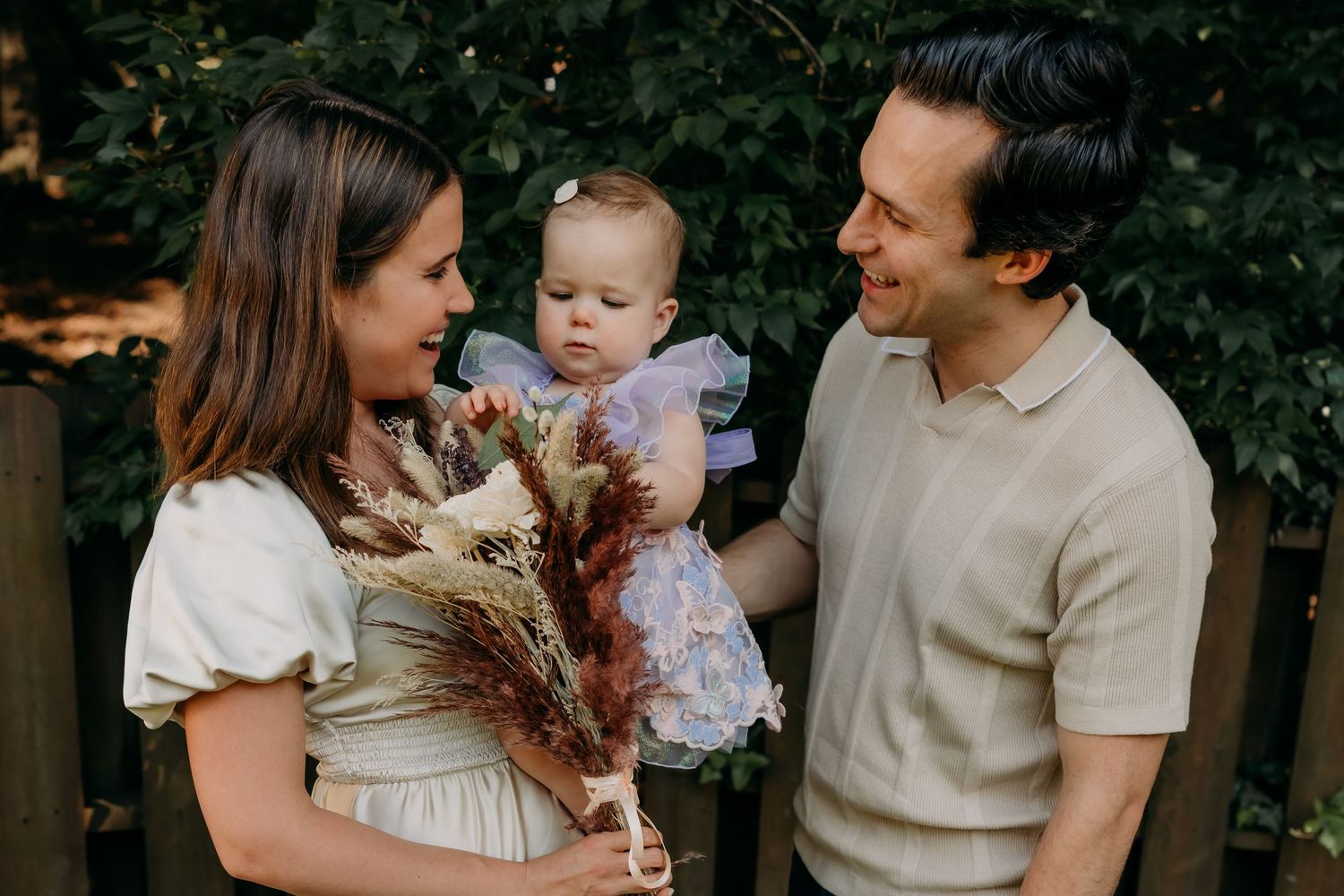 Happy group enjoying a tender outdoor moment together as someone holds a dried floral bouquet.