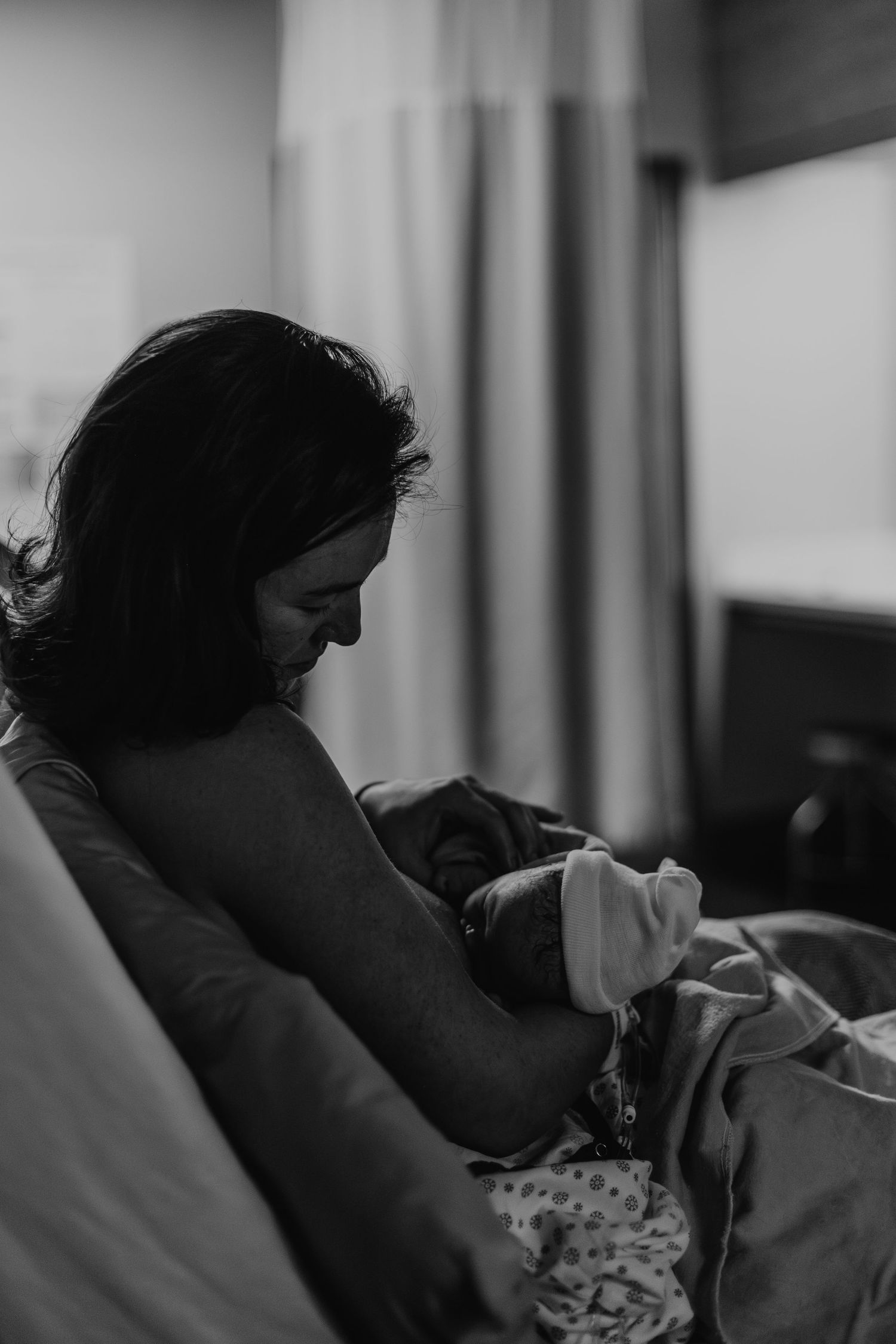 Mother holding her newborn baby moments after birth, breastfeeding them