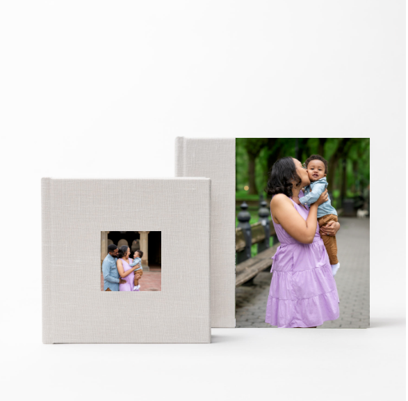 Professional portrait prints displayed in white albums showing dramatic low-key studio photography with moody lighting.