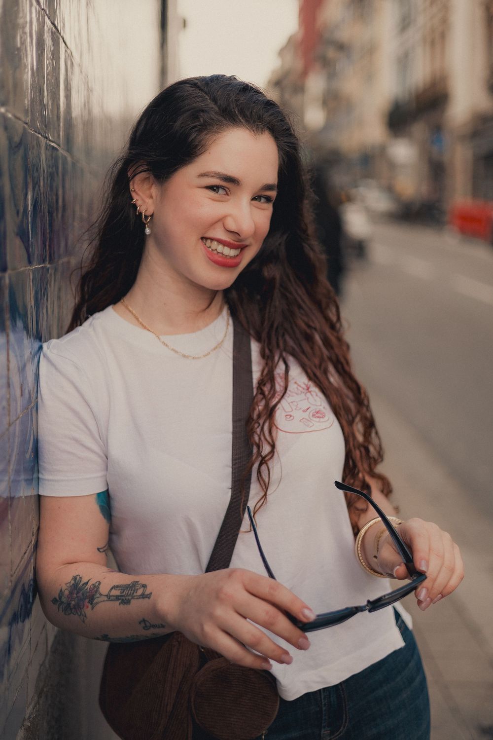Candid street fashion photos showing white t-shirt and dark jeans against urban backdrop.