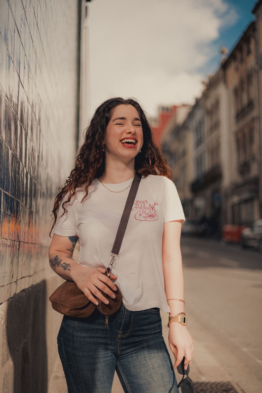 Street style photos featuring white t-shirt and jeans with urban architecture in background.