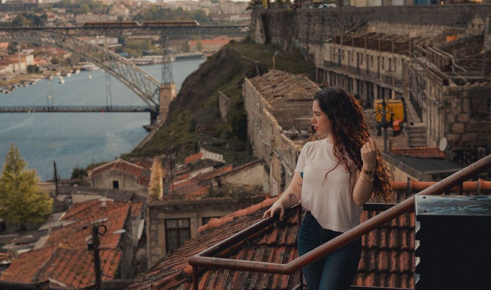 Scenic lifestyle photo overlooking Porto's iconic bridges and red-tiled roofs.