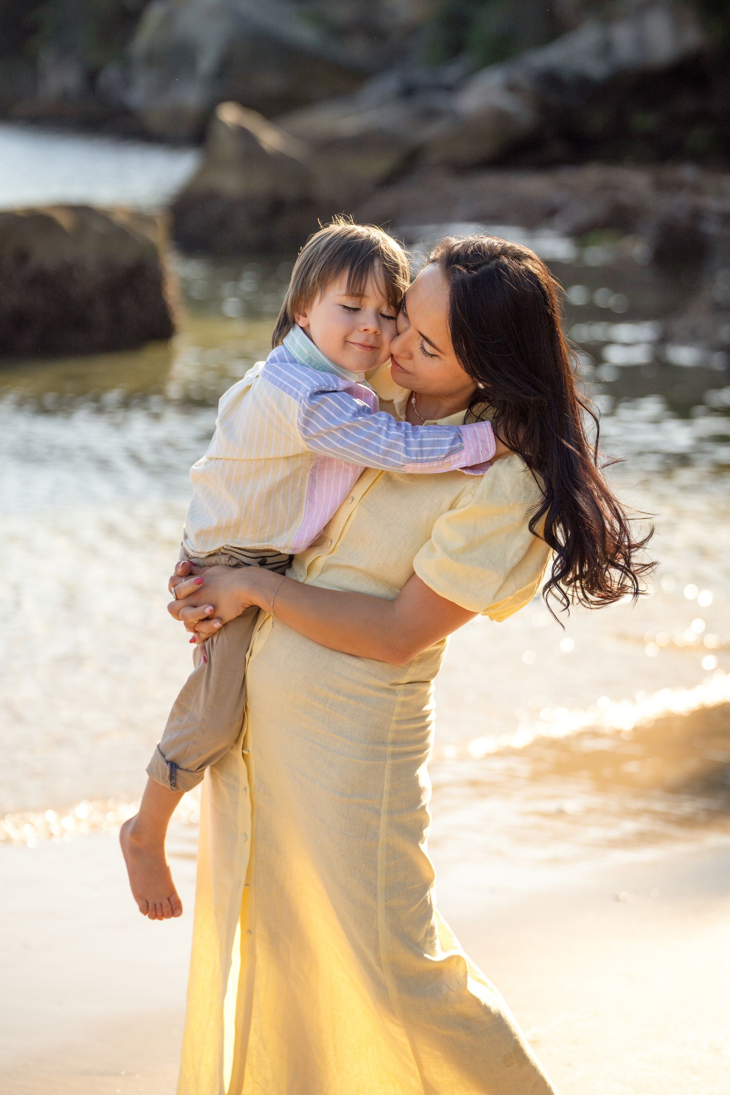 family photographer in Sydney Manly  captures mom and son emotional hug during a golden hour time
