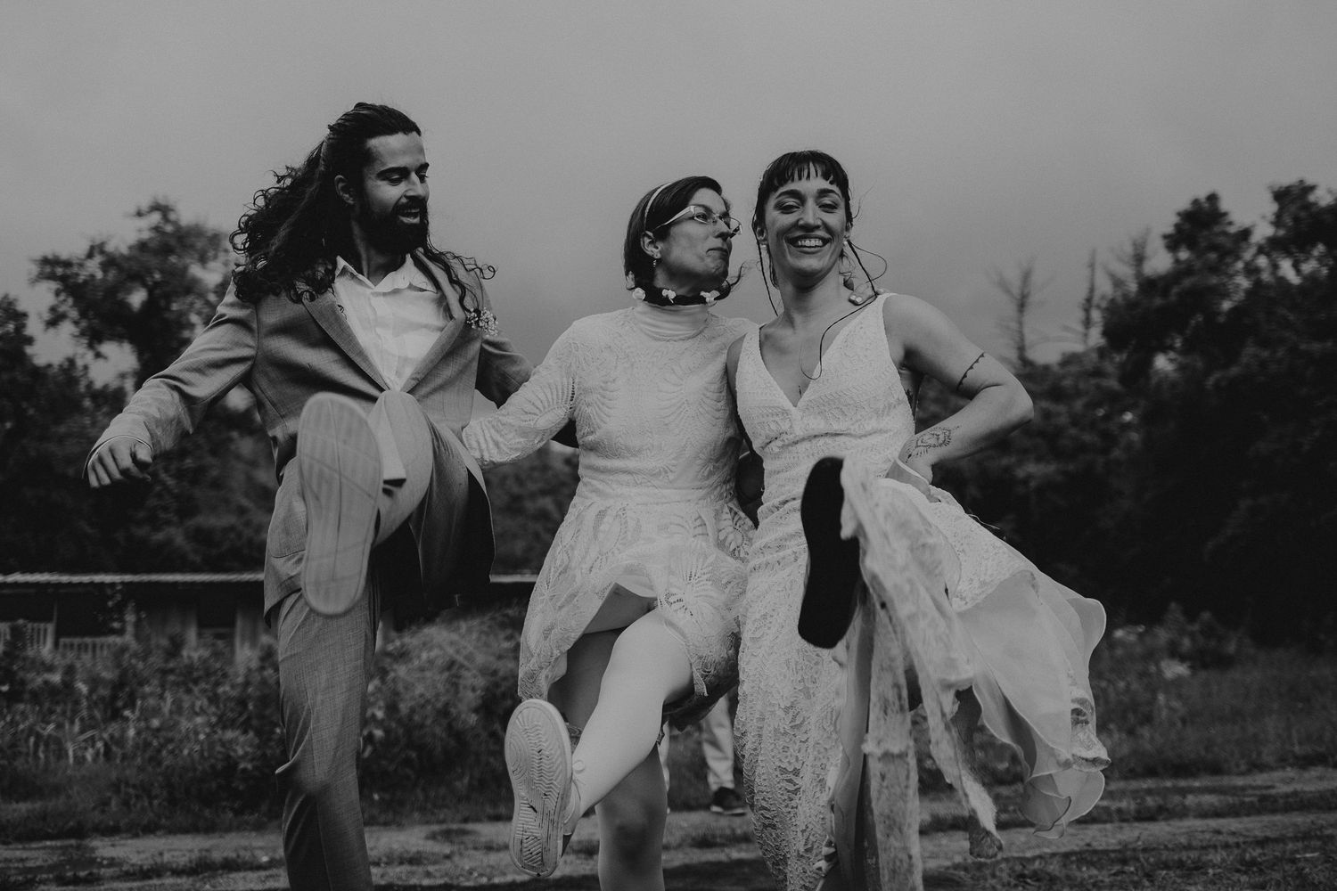 Foto preto e branco, noivos dançam com amiga no brinde do casamento na natureza em Leiria