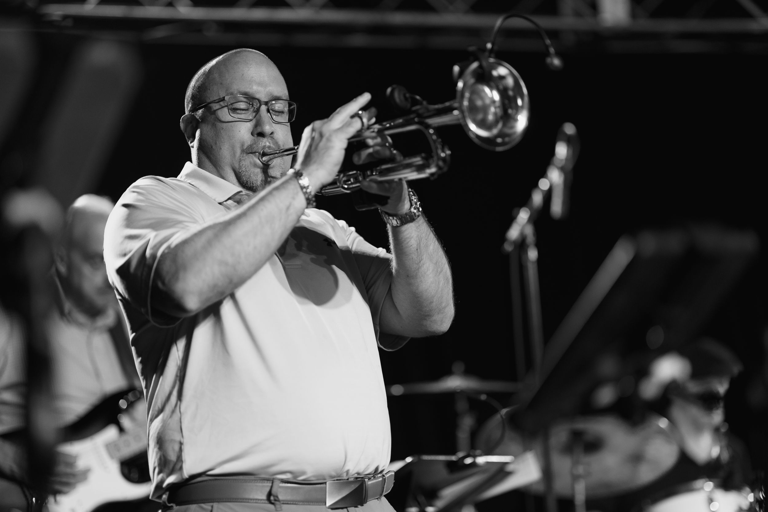A trumpet player performs passionately on stage during a live jazz concert.