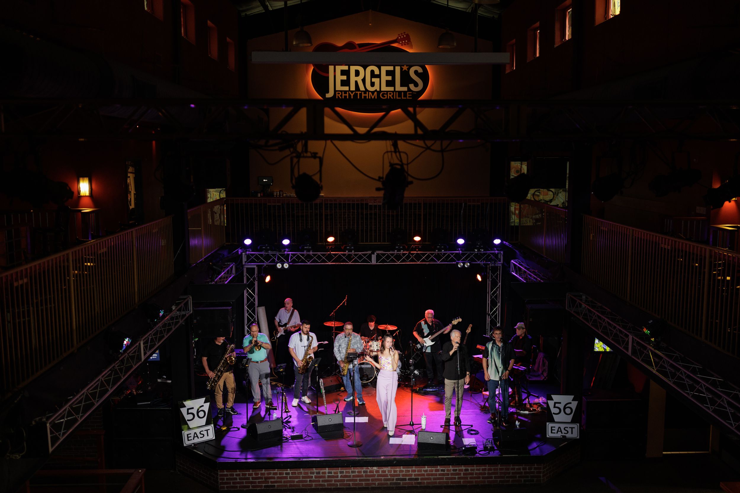 A band performs on stage under purple lighting at Jerrel's music venue with audience visible.