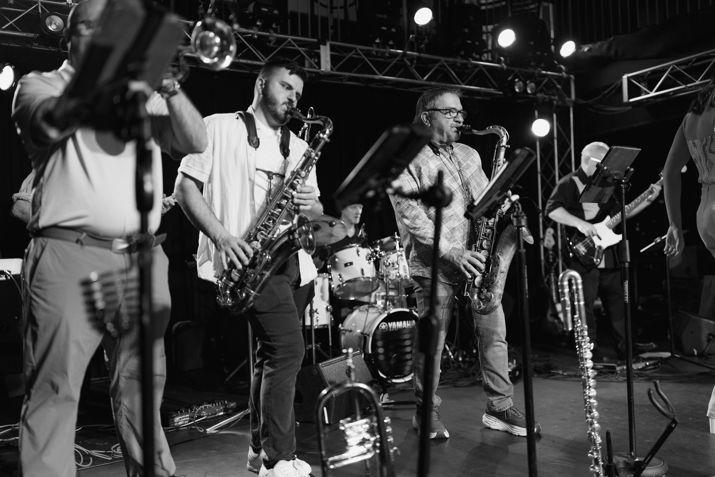 Black and white photo series showing musicians performing on stage with various instruments during a live show.