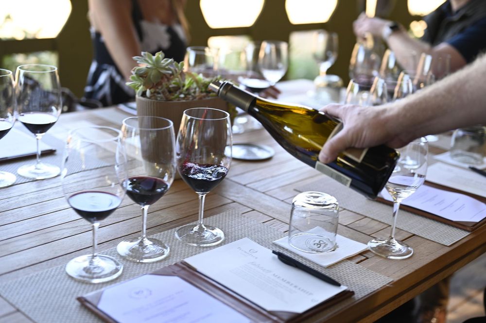 Wine glasses and tasting notes arranged on a wooden table for a wine tasting experience in Saint Helena California.