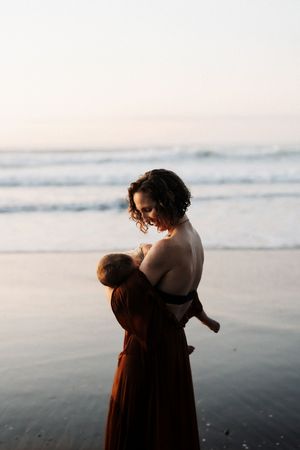 A quiet moment shared between parent and child on a peaceful beach at dusk.