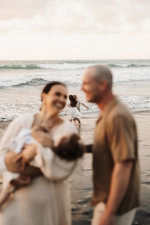 Candid moments captured at the beach with ocean waves in background during sunset.