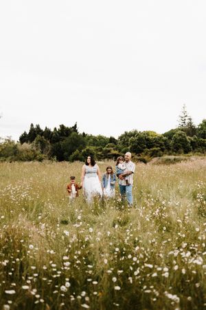 Family strolling through a blooming meadow during golden hour.