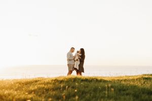 Couple sharing tender moment on hilltop during golden hour.