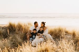 A group enjoys a peaceful moment in tall golden grass by the ocean.
