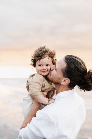 Tender moment captured during sunset at beach.