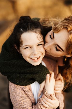 Intimate moment between parent and child sharing laughter in warm sunlight.