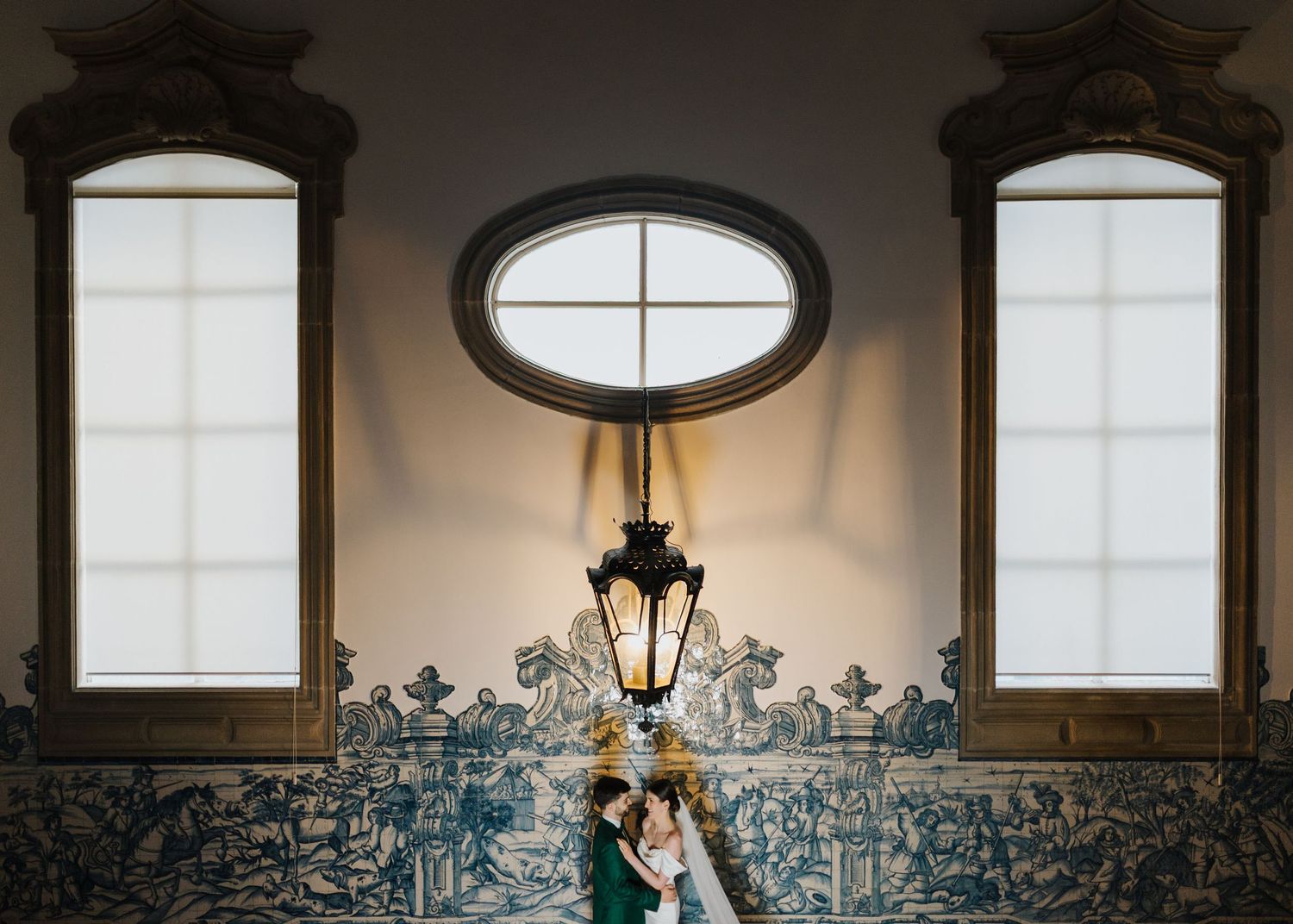 Elegant interior with ornate windows and lantern featuring decorative blue and white tile wall.