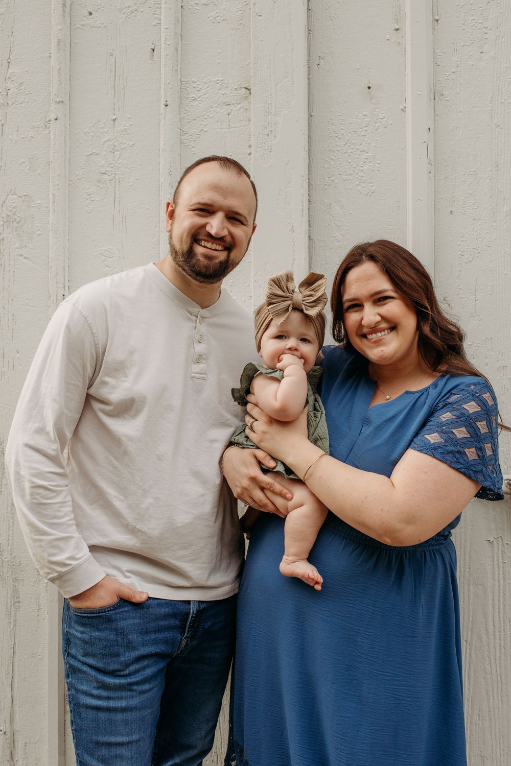 Family portrait series showing warm smiles and embraces against a white wall background.