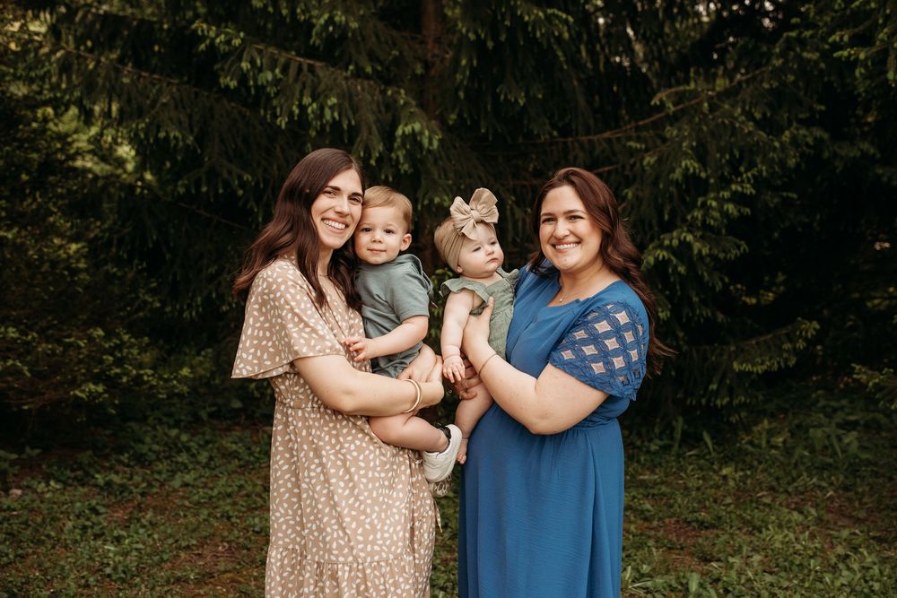 A heartwarming family moment captured outdoors with four people embracing.