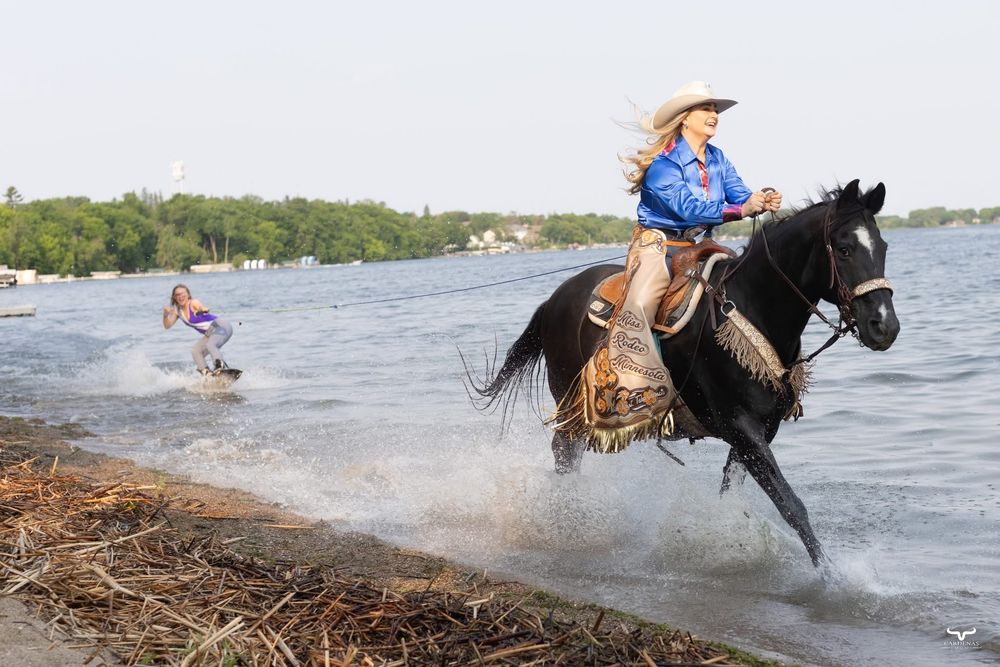 A horse and rider splash through water at the edge of a lake. Pro Rodeo PRCA Rodeo Photographer Dakota Cardenas
