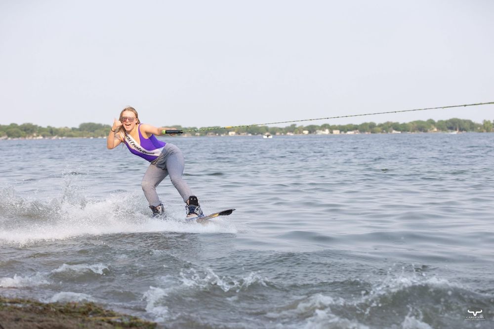 A water skier performs on a lake with splashing waves. Pro Rodeo PRCA Rodeo Photographer Dakota Cardenas