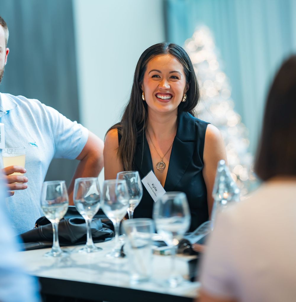 Someone enjoying an animated conversation at an upscale restaurant dinner table with wine glasses.