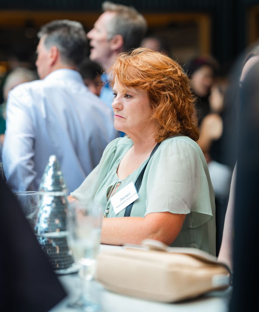 A candid scene of people in restaurant-style seating, with sunlight and selective focus creating a soft ambiance.