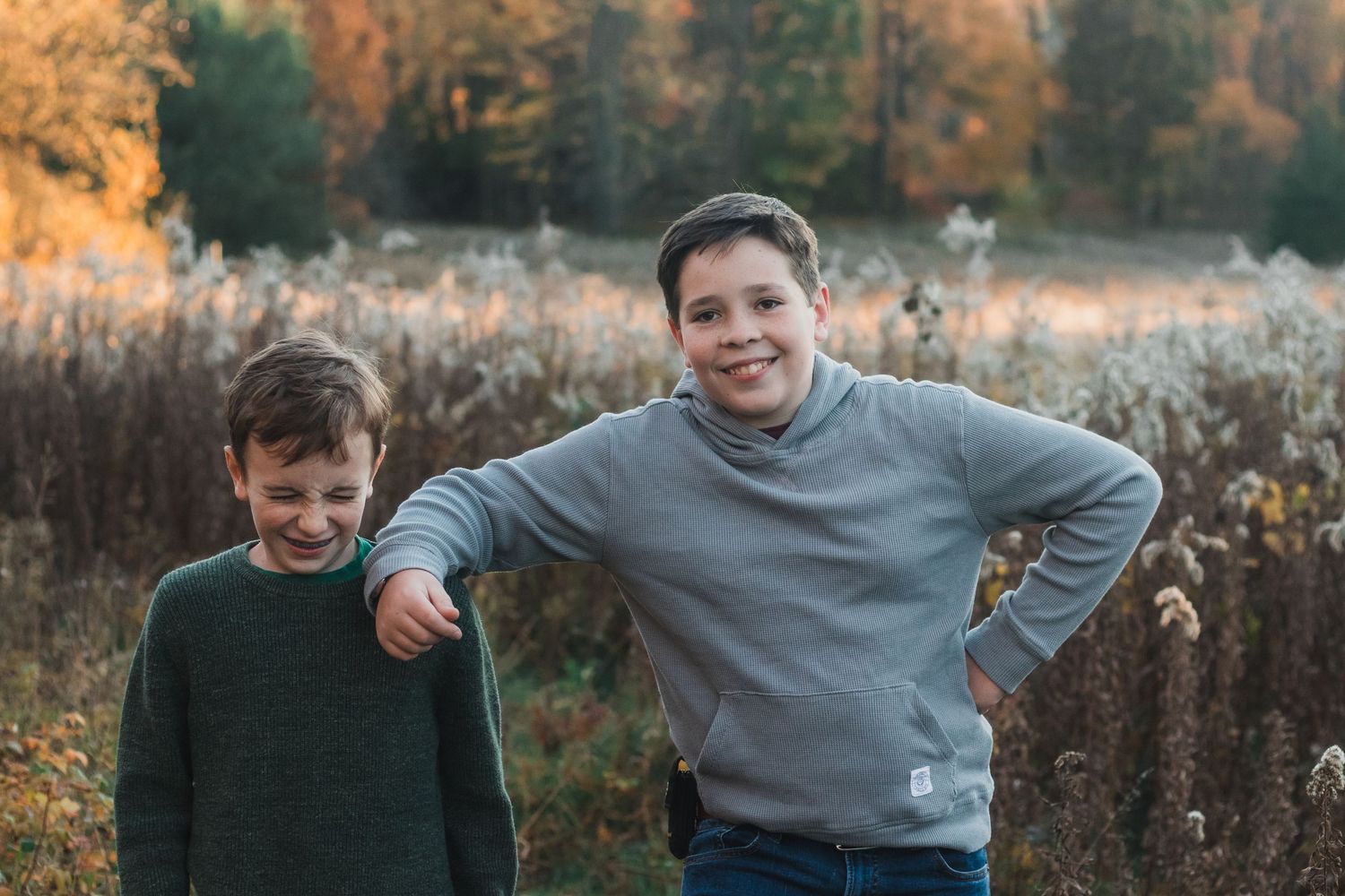 Two brothers posing during a golden hour lifestyle family photography session - lifestyle family photographer in South Lyon, Michigan.