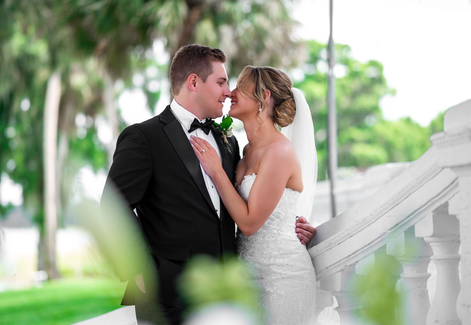 Bride & Groom kiss under the Oak tree at Bella Cosa wedding venue, captured by Treasure Coast Wedding Photographers.