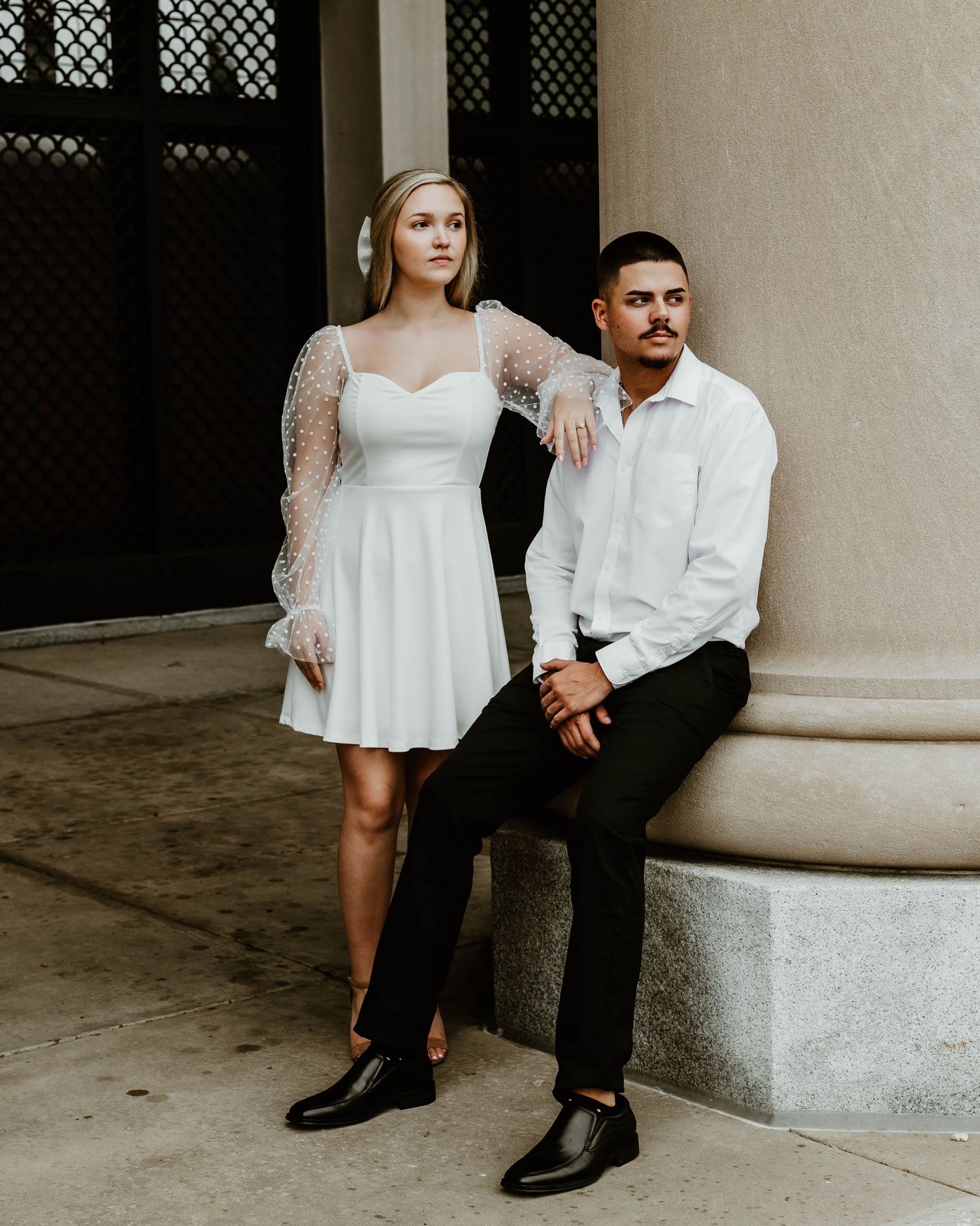 Editorial-style engagement photos on concrete steps | Couple in black & white attire exudes modern, minimalist, luxury portrait vibes.