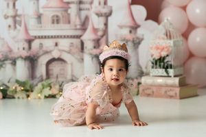 Princess themed first birthday setup with pink castle backdrop and balloons.