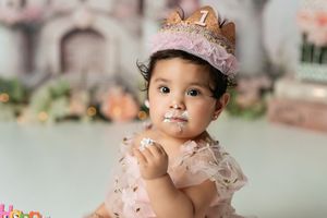 Elegant pink castle setup with white balloons and floral arrangements for a fairy tale photoshoot.