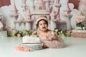 Whimsical pink castle scene with delicate floral accents and a birthday cake.