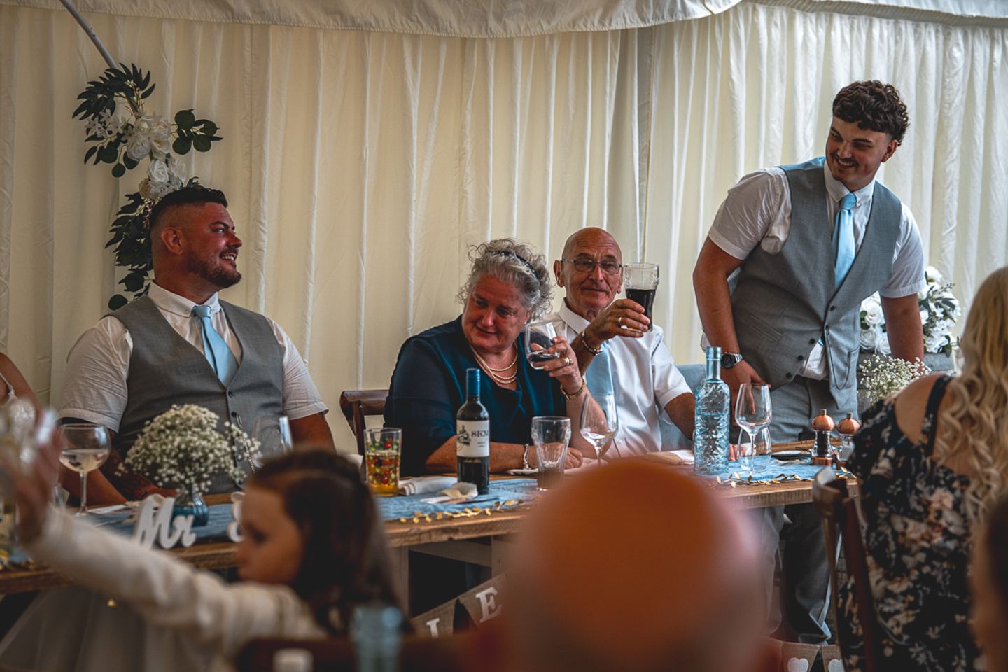 Groom and his son share a smile during wedding speeches by Poole, Bournemouth and Dorset wedding photographer "kris the photographer"