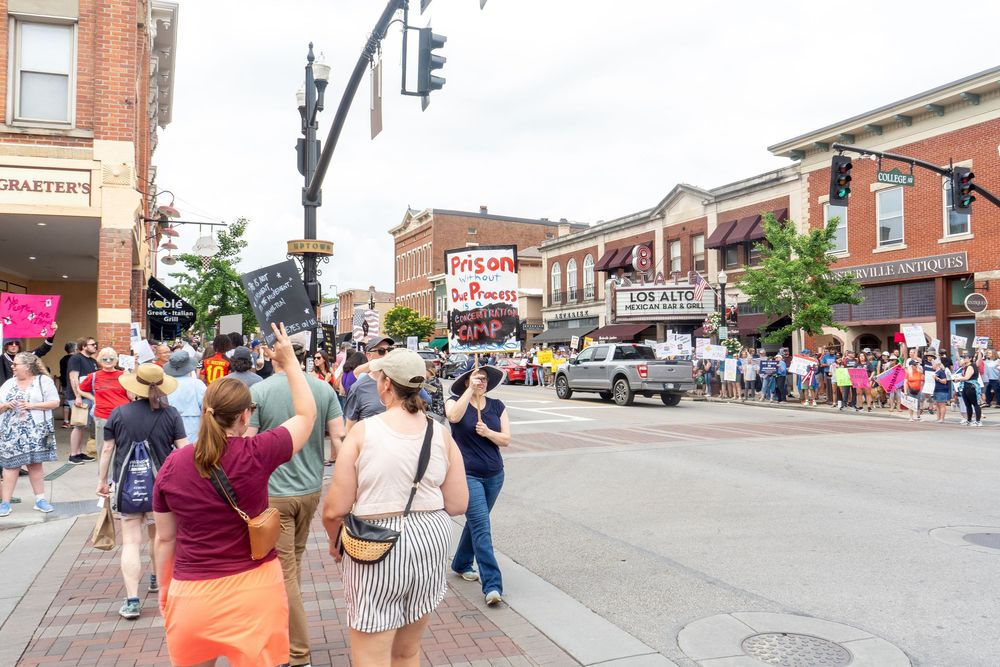 A crowd of people walk down Main Street during No Kings protest
