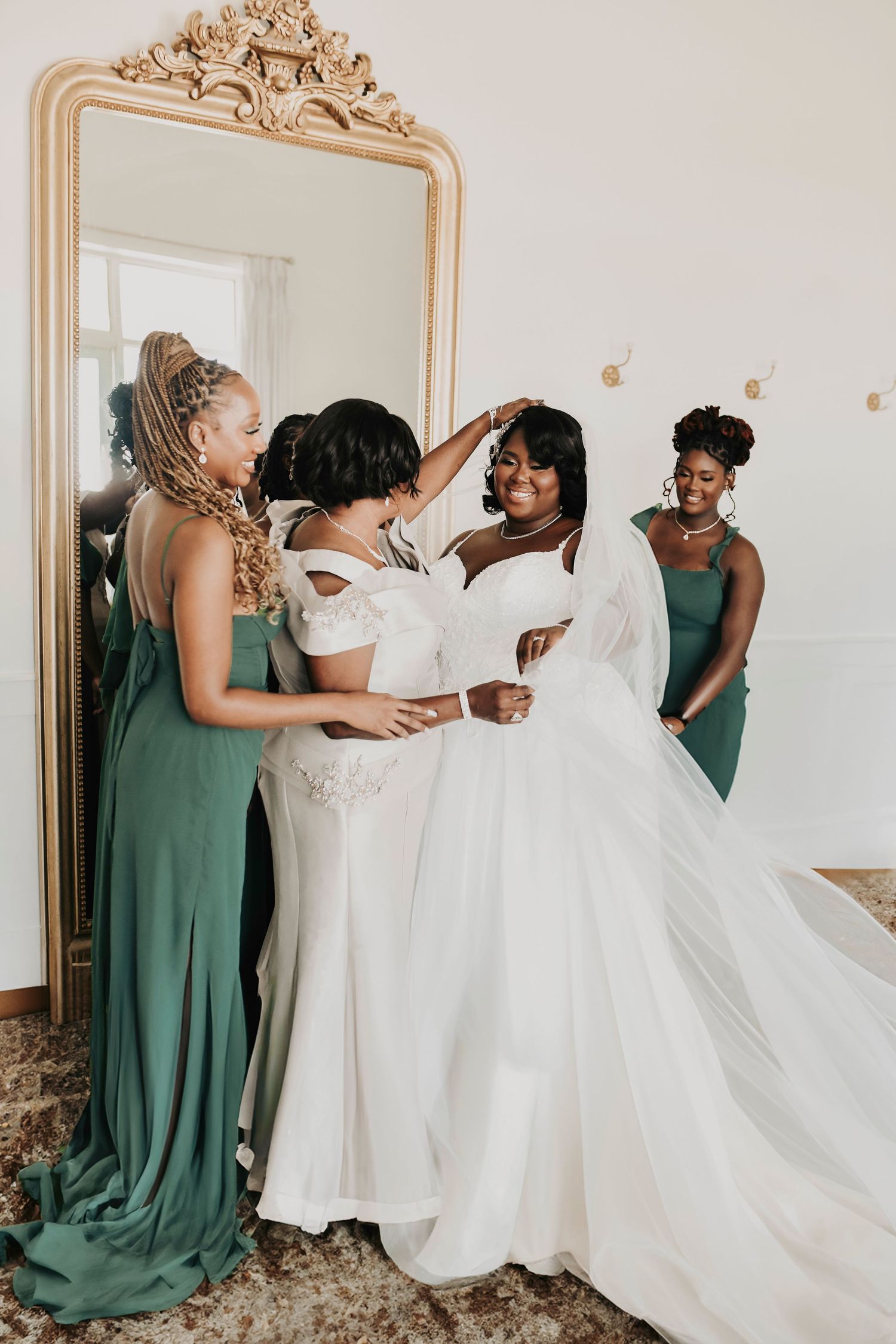 a bride's mother puts on her veil inside of the bridal suite at the gardenia wedding venue
