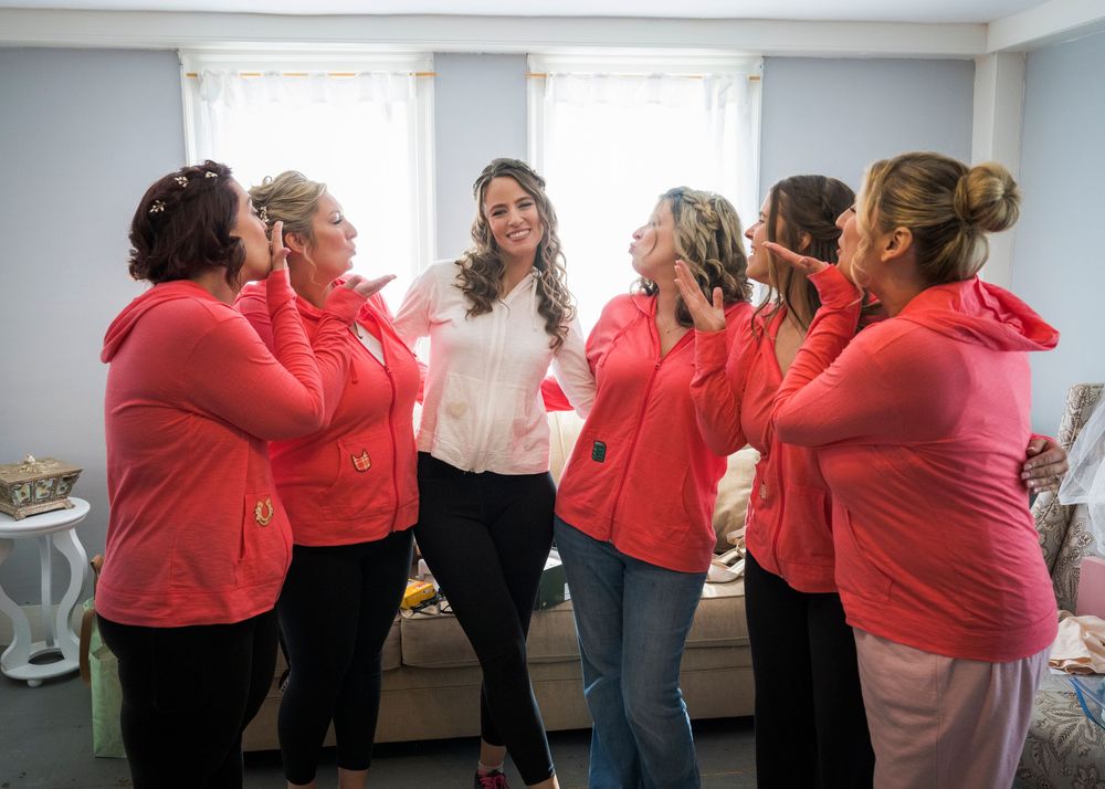A group wearing matching red shirts stands in formation during an indoor gathering.
