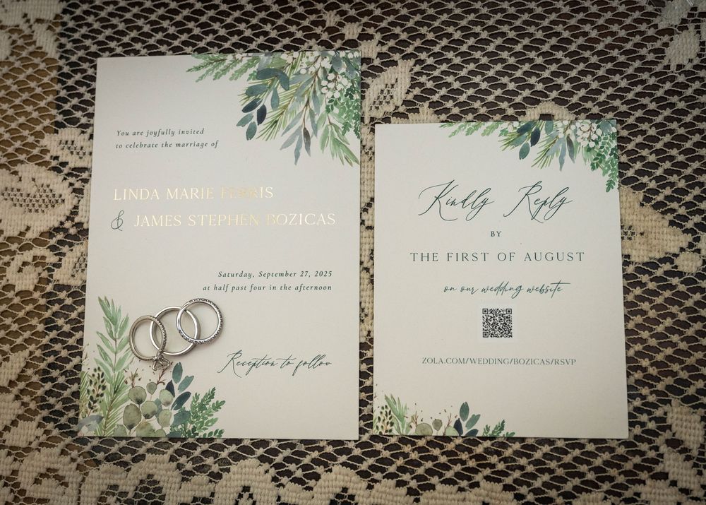 Elegant wedding invitation suite featuring greenery and antler designs on textured paper.