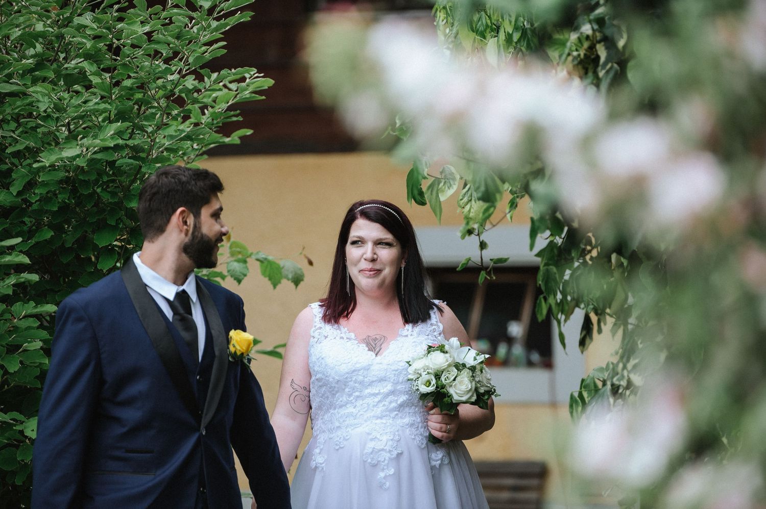 Newlyweds share intimate moments in a lush garden setting during their wedding photoshoot.