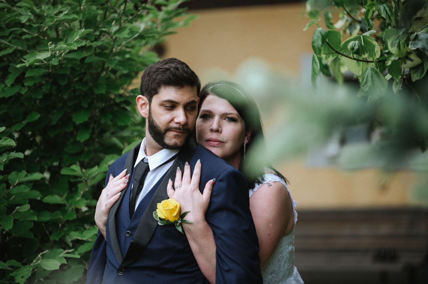 A couple embraces during their wedding photos in a garden with soft natural lighting.