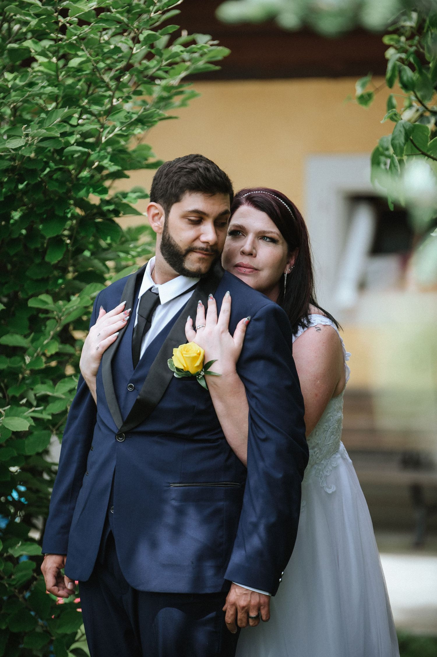A tender moment between newlyweds captured in a garden setting with natural light.