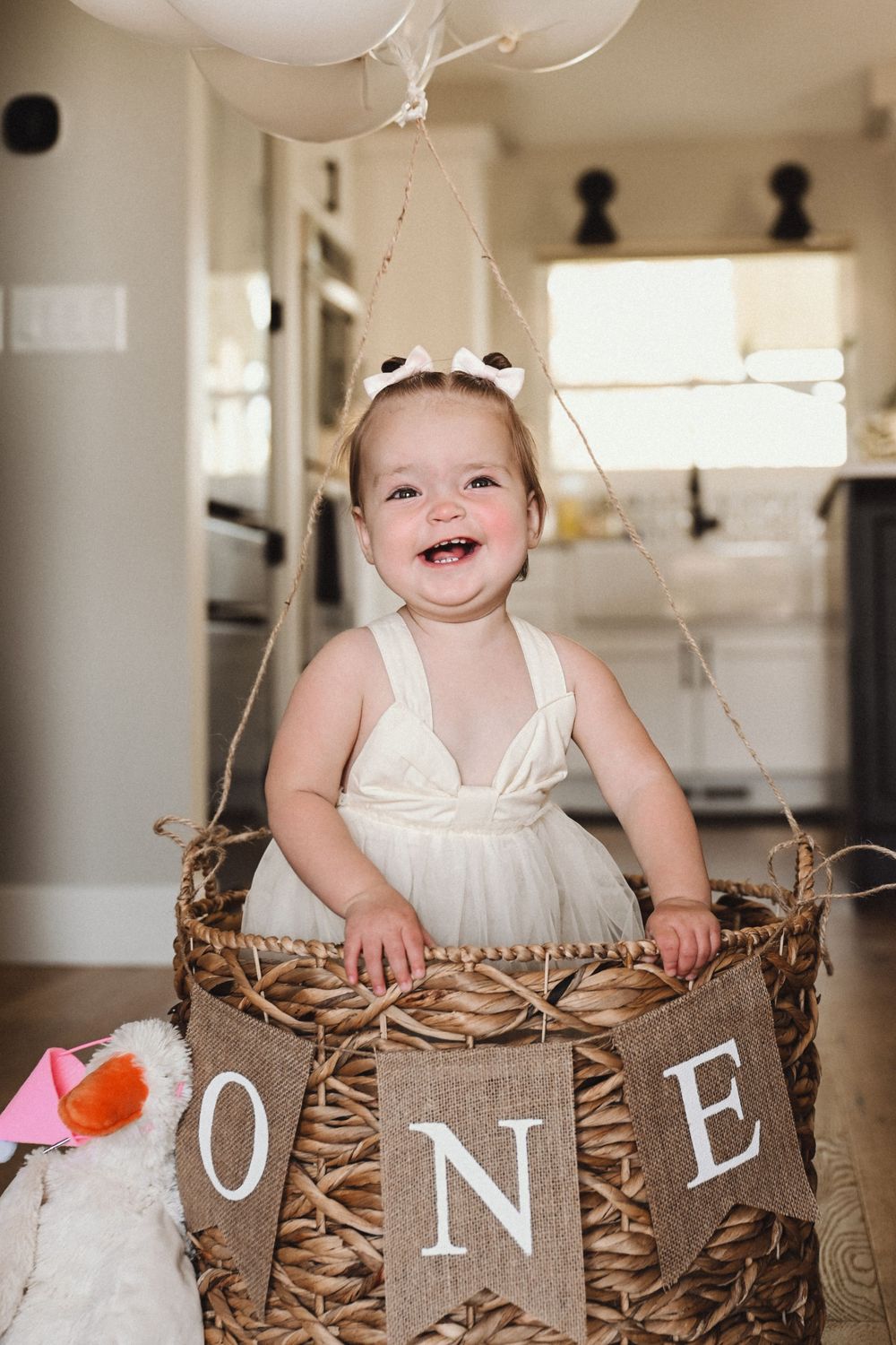 Festive birthday display with decorative letters spelling ONE in rustic baskets.