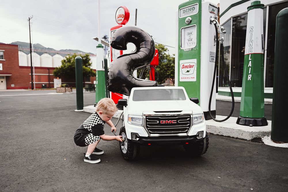 Modern gas station exterior with fuel pumps and white delivery truck.